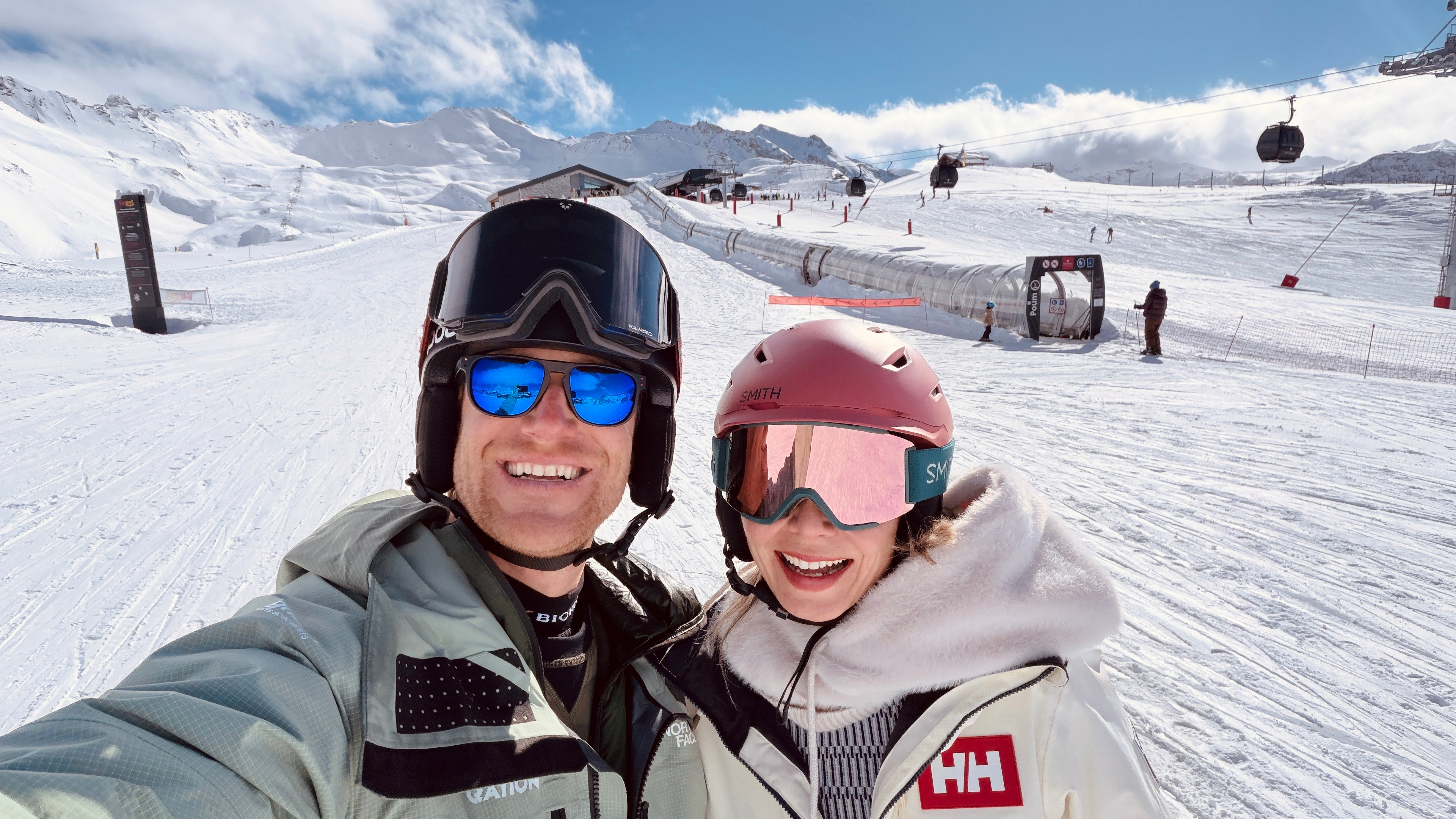 Pascal Prot and a client smiling on the slopes of Tignes in front of the gondola